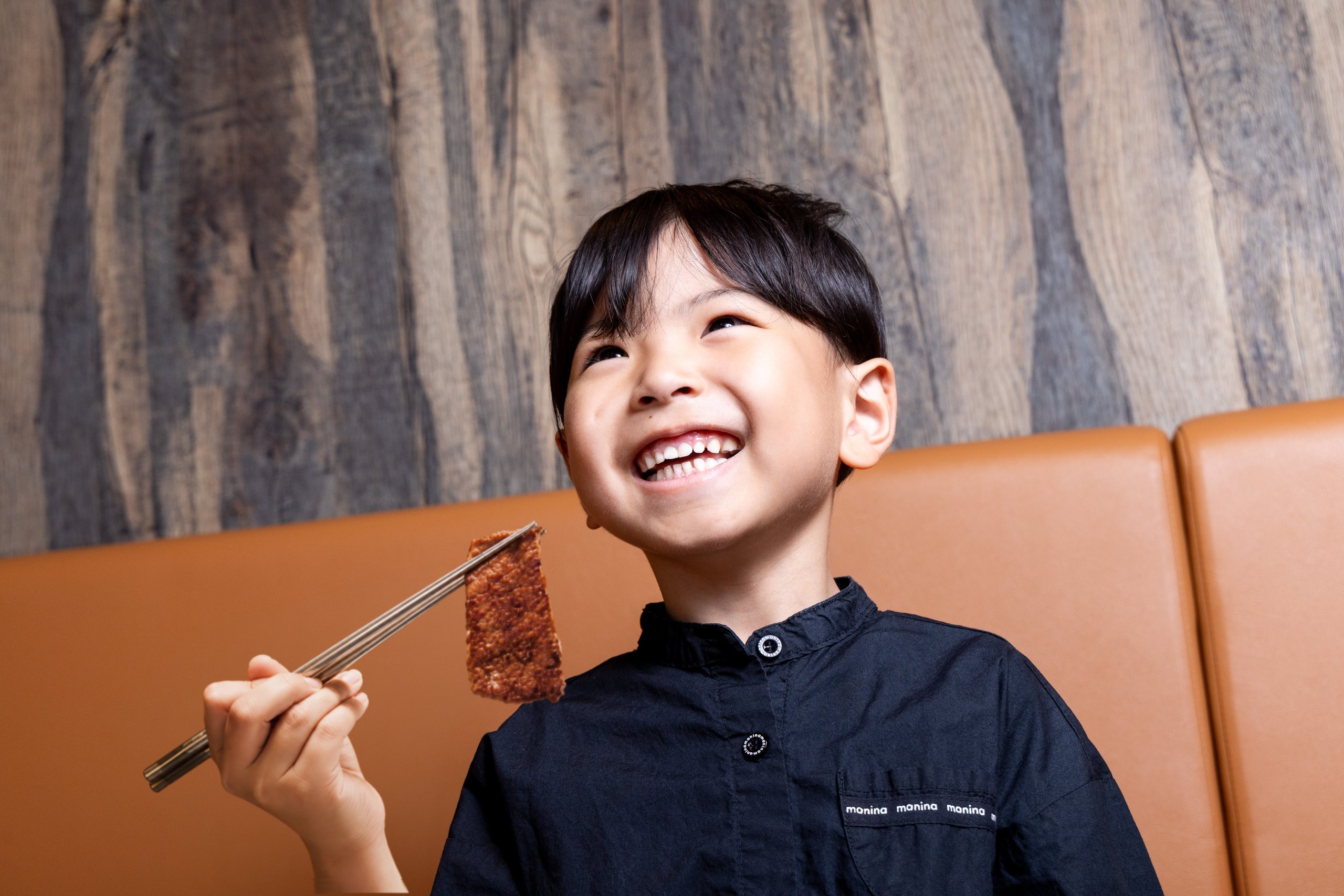 笑顔で焼肉を頬張る子ども